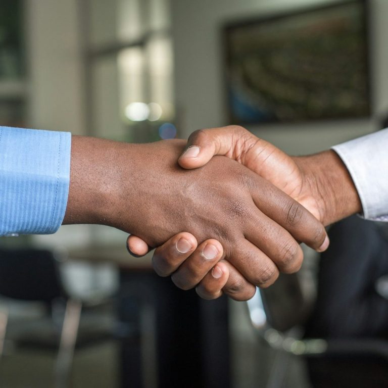 Accord médiation Deux mains se serrent dans un geste de collaboration ou d'accord.
